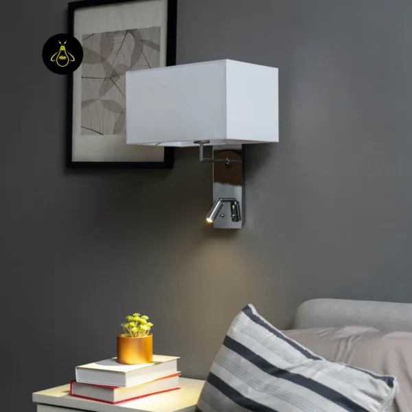 Wall mounted bedside light with only the LED reading spot on, lighting a bedside table