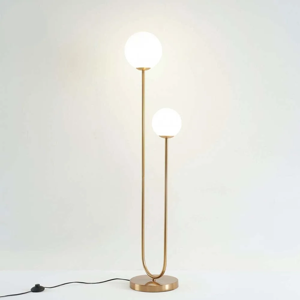 Brass Dual Globe Floor Lamp – Opal Glass, 130 cm Satin Finish 2 Brass floor lamp with two glowing opal globes on a U-shaped stem, foot switch on the cord