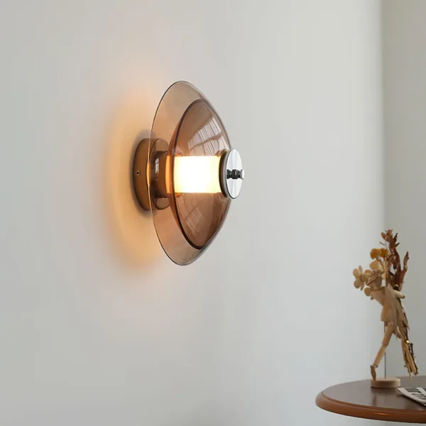 Amber glass wall light casting a warm halo on a living room wall above a round wooden side table
