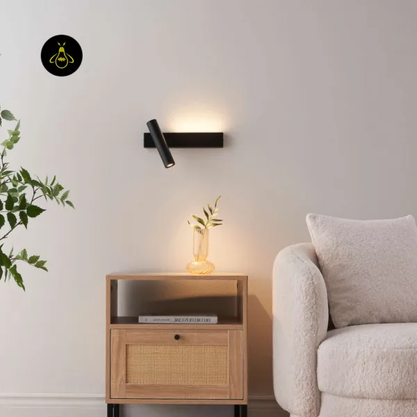 Black wall reading lamp above a wooden nightstand next to a white bouclé armchair