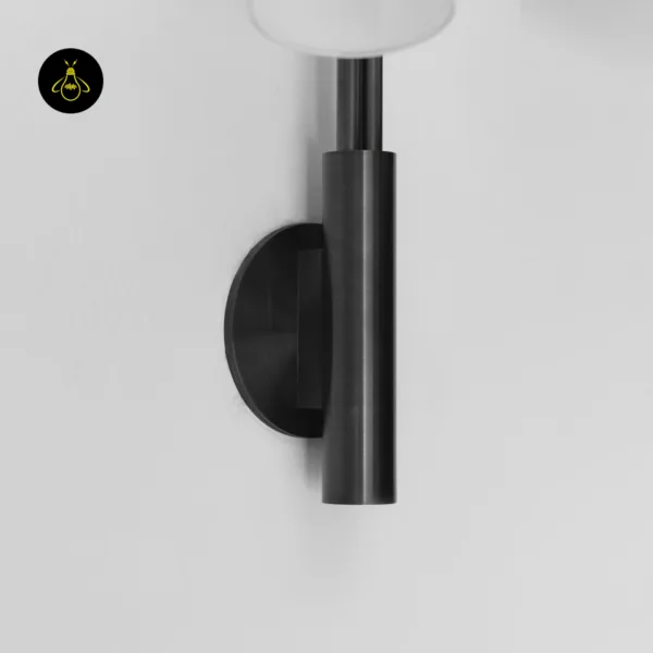 Dark bronze 304-grade stainless steel column and round backplate of a gooseneck wall sconce on a white wall