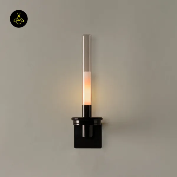 Candle wall light lit, front view with the round black collar and square stainless steel backplate