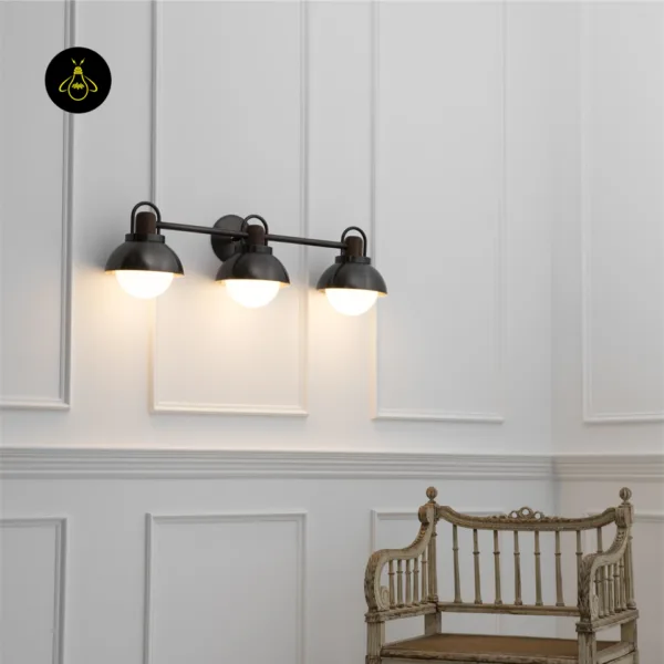 Vanity wall light glowing warm on a white panelled wall above a carved wooden chair