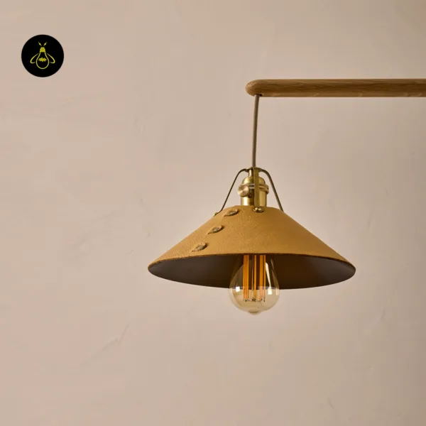 Close-up of a leather-clad brass cone shade on the wood and brass chandelier