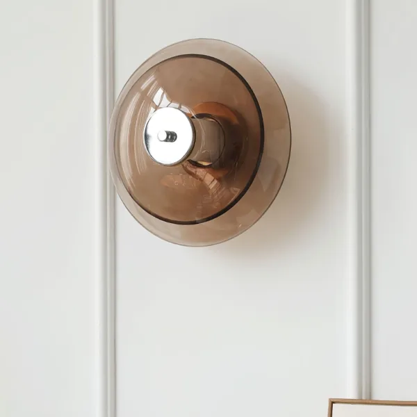 Amber glass wall light switched off, front view of the amber borosilicate glass saucer and polished chrome stainless steel cap