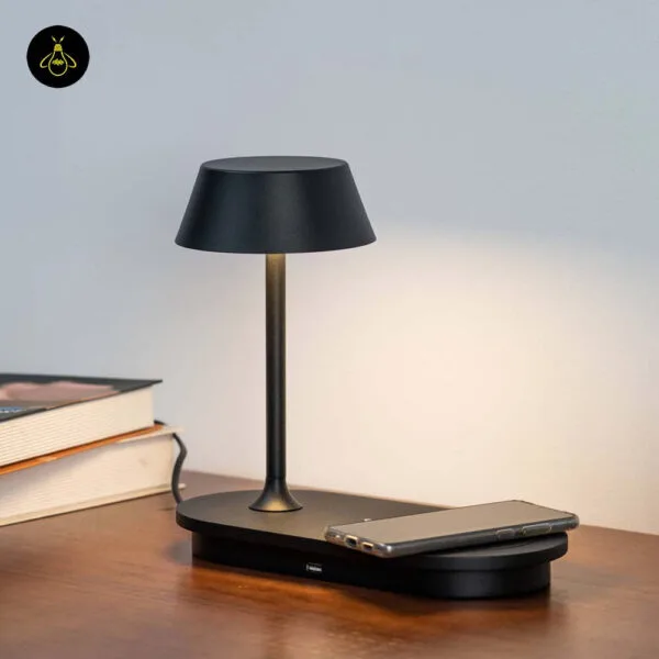 LED table lamp with wireless charging pad in matte black on a bedside table