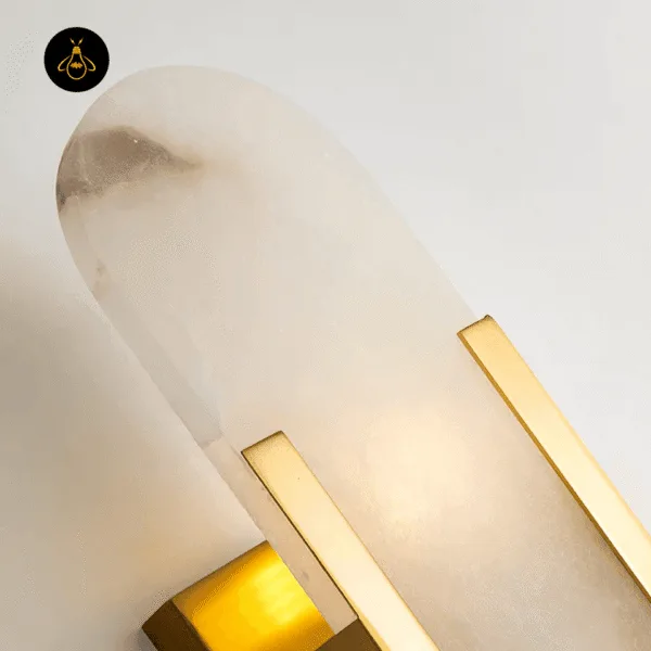 Close-up of the natural alabaster capsule and gold-finish stainless steel side bar of the linear alabaster wall light