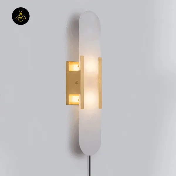 Linear alabaster wall light lit, gold-finish frame, front view on a grey wall