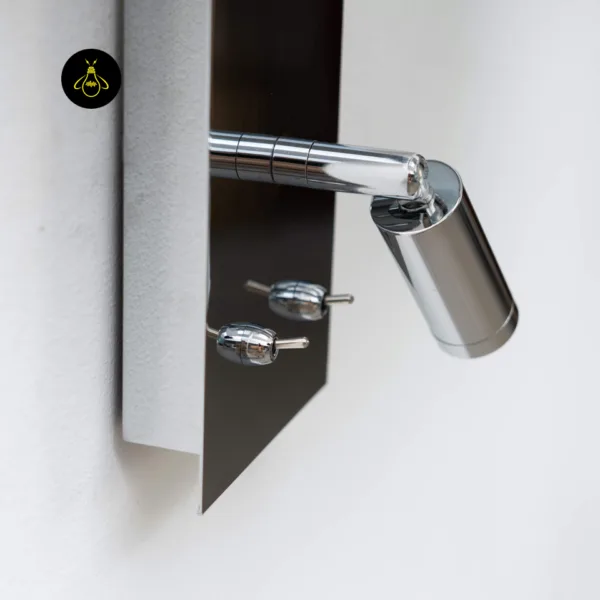 Close-up of the swivel 1 W LED reading spot and two toggle switches on the polished chrome stainless steel plate