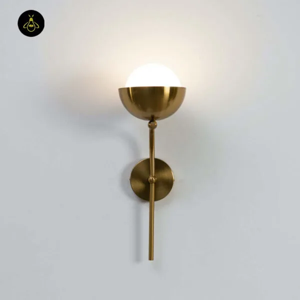 Opal white light lit, front view of the globe wall lamp on a white wall