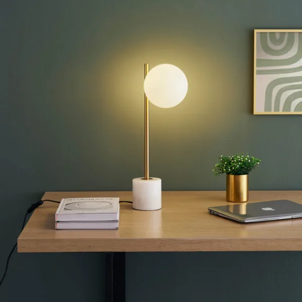 Marble and brass table lamp with opal borosilicate glass globe on a study desk