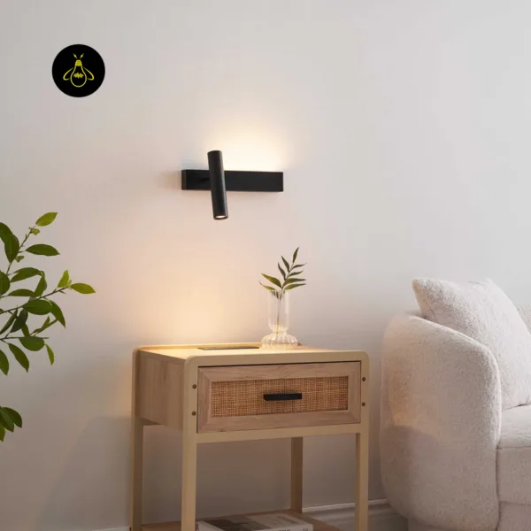 Matte black wall reading lamp over a wooden side table in a reading corner