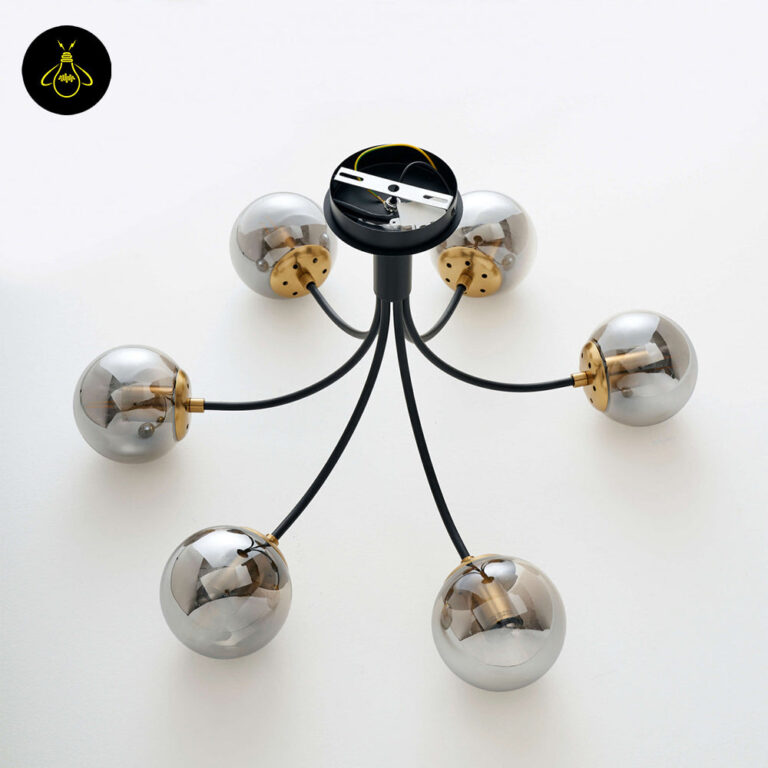 Close-up of matte-black chandelier arm and brass-finish bulb cup
