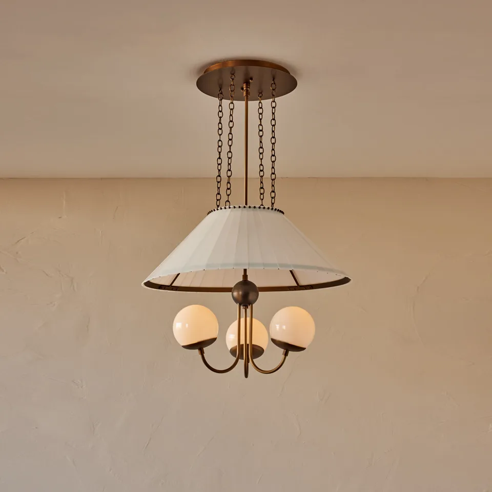 Milk glass chandelier with three milk-glass globes and antique brass arms