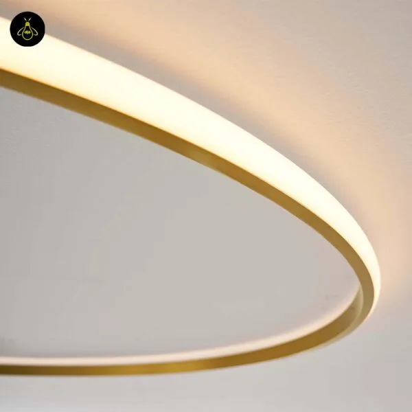 Minimalist brass LED ring light over a dining area