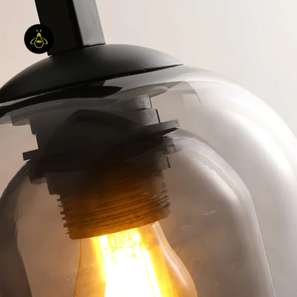 Close-up of fancy lights for wall: E27 bulb holder under a black stainless steel cap inside smoked borosilicate glass