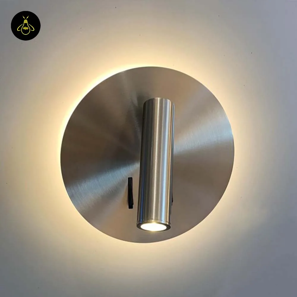Wall Mounted Reading Light – LED Double Light, Chrome Finish 2 Wall lamp for bedroom lit, warm 3000K halo glowing around the brushed steel disc, reading spot pointing down