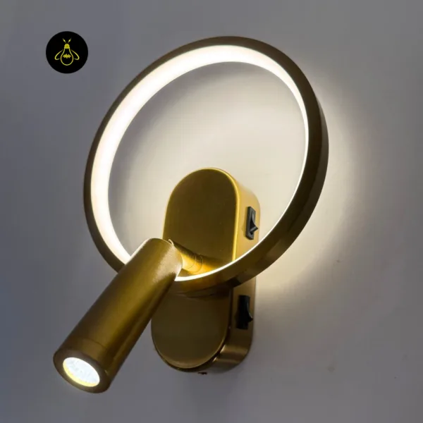 Gold circle wall light close-up with both switches on the backplate and the spot lit