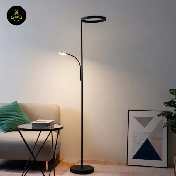 Modern black LED floor lamp with ring uplight and reading arm beside a sofa
