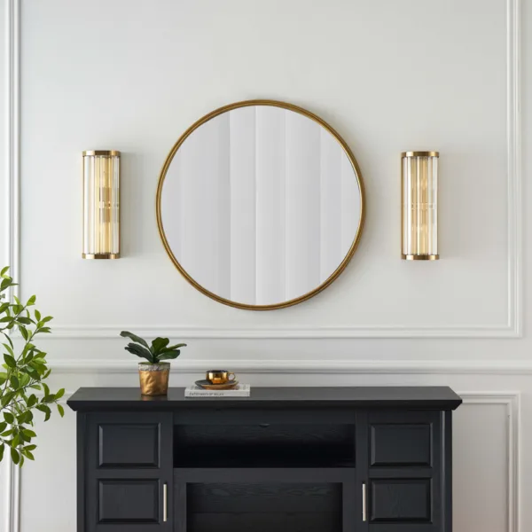 Pair of ribbed glass wall lights either side of a round mirror above a black console, styled for a living room