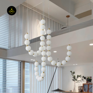Pearl necklace chandelier with a warm neutral glow and gold finish