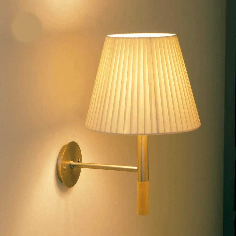 Fabric wall light lit warm, pleated raw silk shade on a satin nickel stainless steel arm with wood accent, three-quarter front view