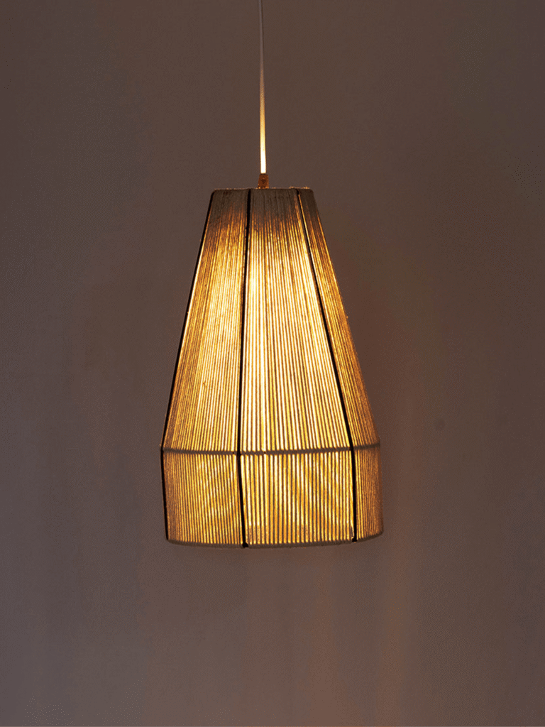 Woven pendant light with natural raffia cone shade glowing warm over a grey wall