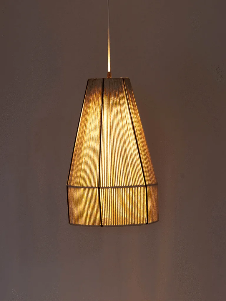 Woven pendant light with natural raffia cone shade glowing warm over a grey wall