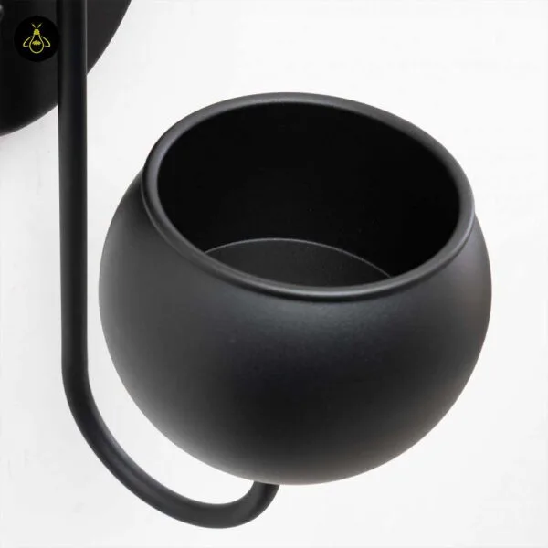 Close-up of the empty matte black stainless steel planter cup on the plant pot wall light curved arm
