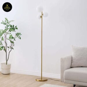 Gold glass globe floor lamp styled beside a sofa in a hotel-style lobby