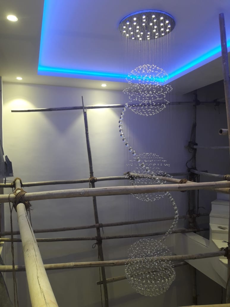 Residential chandelier Ranchi triple-sphere crystal cascade during installation