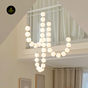 Pearl necklace chandelier cascading over a staircase in a double-height void
