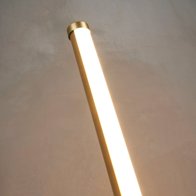 Close-up of gold LED floor lamp showing the slim illuminated stem