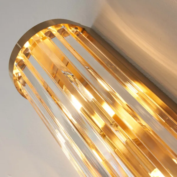 Close-up of the lit ribbed glass wall light from below, warm light running through the clear borosilicate glass rods