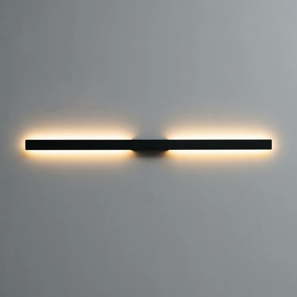 Slim LED wall light with 60 cm matte black linear bar and warm indirect glow mounted horizontally
