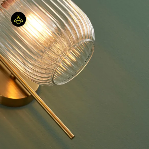 Underside of the fluted glass wall light shade showing the clear glass ribs and open rim