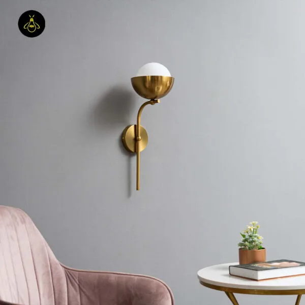 Opal white light unlit on a grey wall beside a pink velvet chair and a marble side table