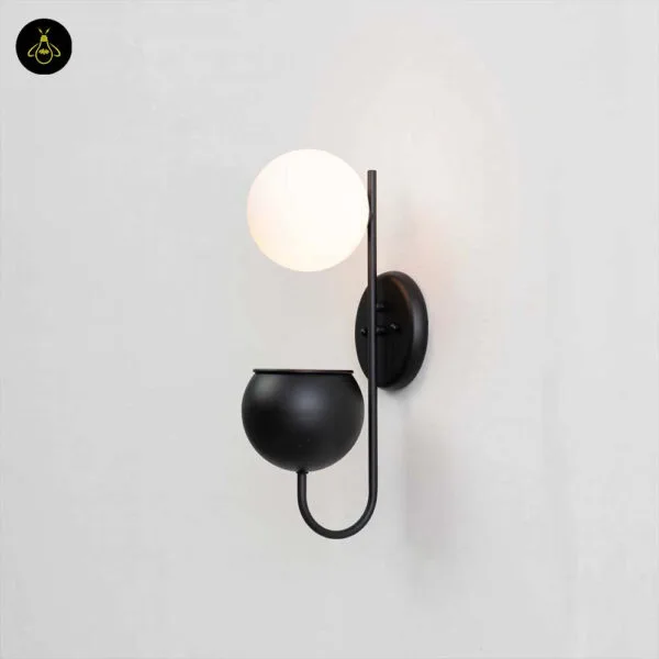 Plant pot wall light lit on a pale wall, showing globe, backplate and planter cup
