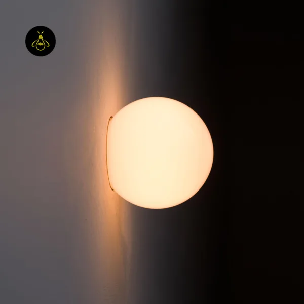Close-up of the alabaster wall light glowing warm, side view of the stone globe against the wall