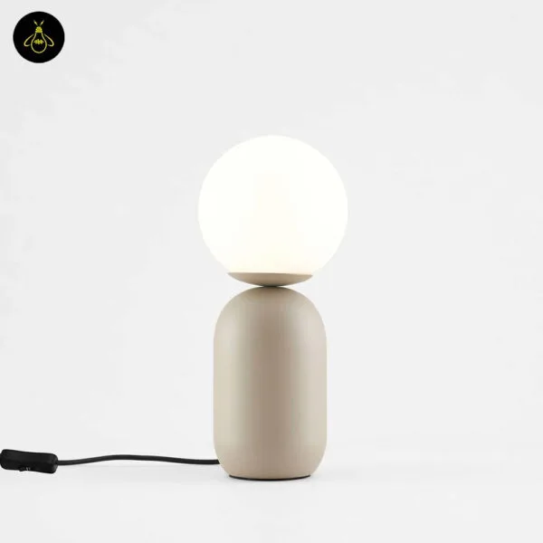 Taupe table lamp with white globe styled on a bedroom nightstand