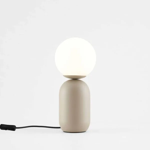 Taupe table lamp with white globe styled on a bedroom nightstand