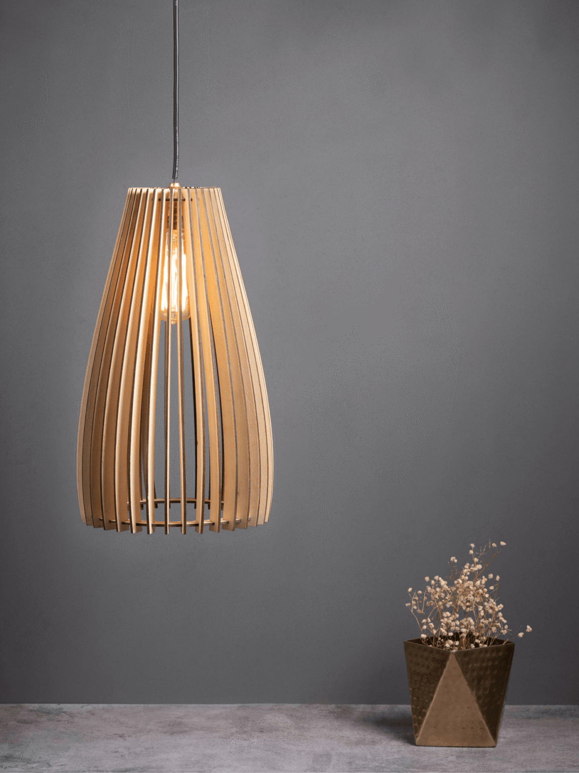 Wooden pendant light with a slatted teardrop birch shade glowing warm over a styled console