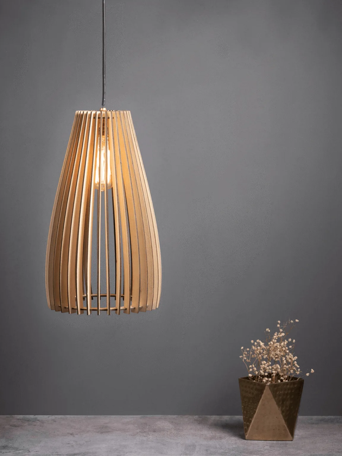 Wooden pendant light with a slatted teardrop birch shade glowing warm over a styled console