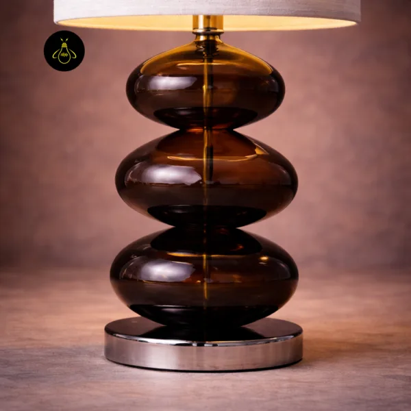 Close-up of amber glass table lamp on a polished chrome base