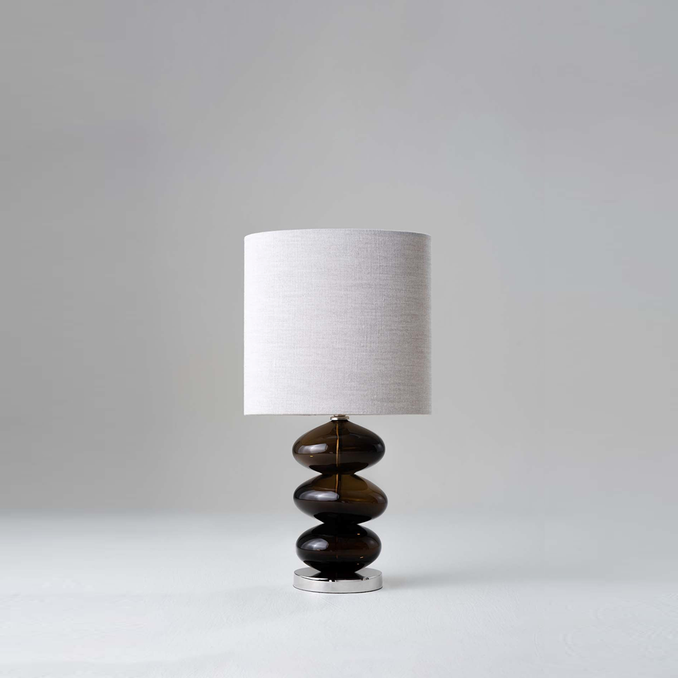 Amber bedside lamp with stacked glass body and fabric shade