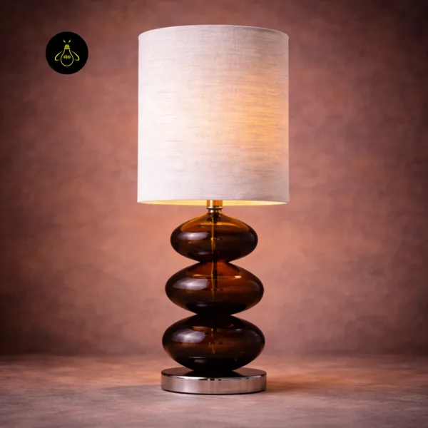 Front view of amber glass table lamp with three stacked glass pebbles