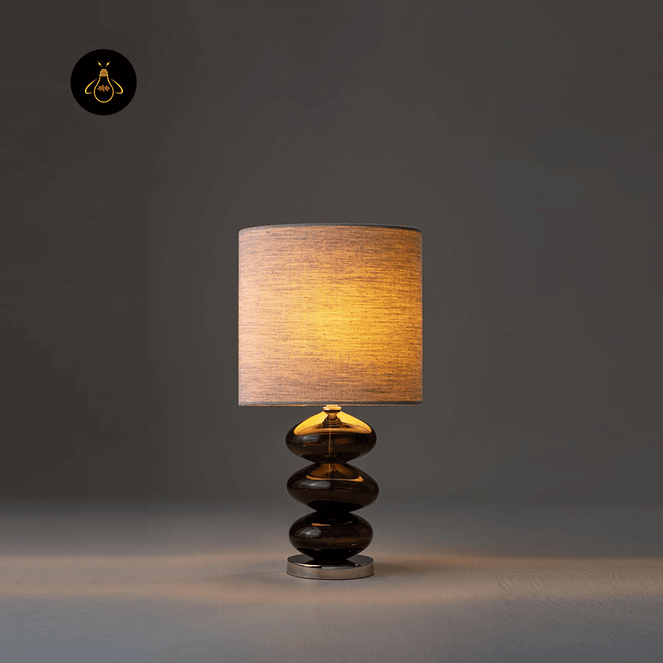 Glass Table Lamp – Amber Stacked-Pebble Base, 52 cm 2 Glass table lamp glowing warm amber on a bedside surface