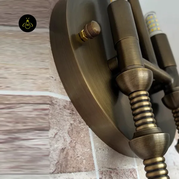 Side close-up of the alabaster dome wall light backplate and rod joints in antique brass finish on 304 stainless steel