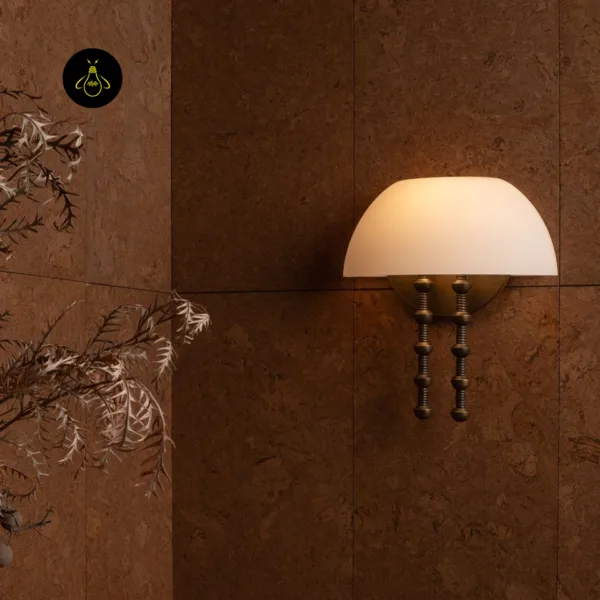 Alabaster dome wall light on a brown textured wall beside dried branches in a room setting