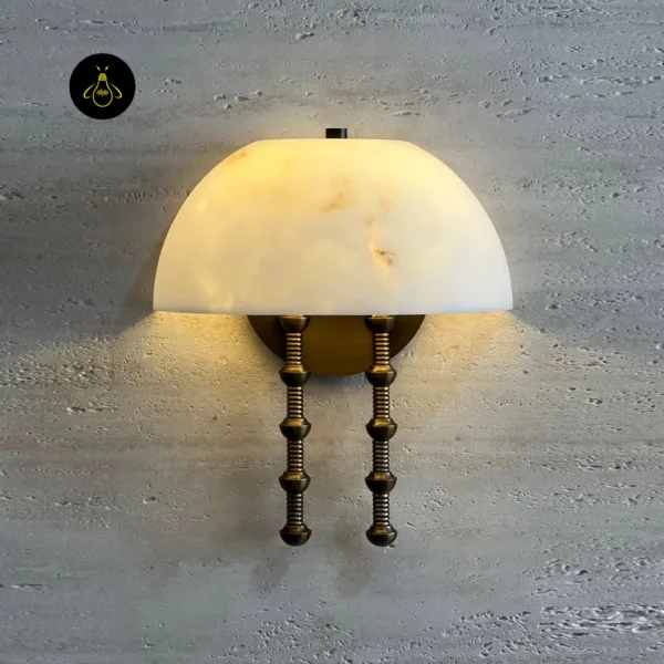 Alabaster dome wall light lit on a pale textured wall, showing veins in the stone shade